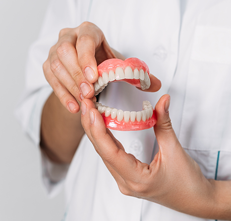 A person holding a denture.