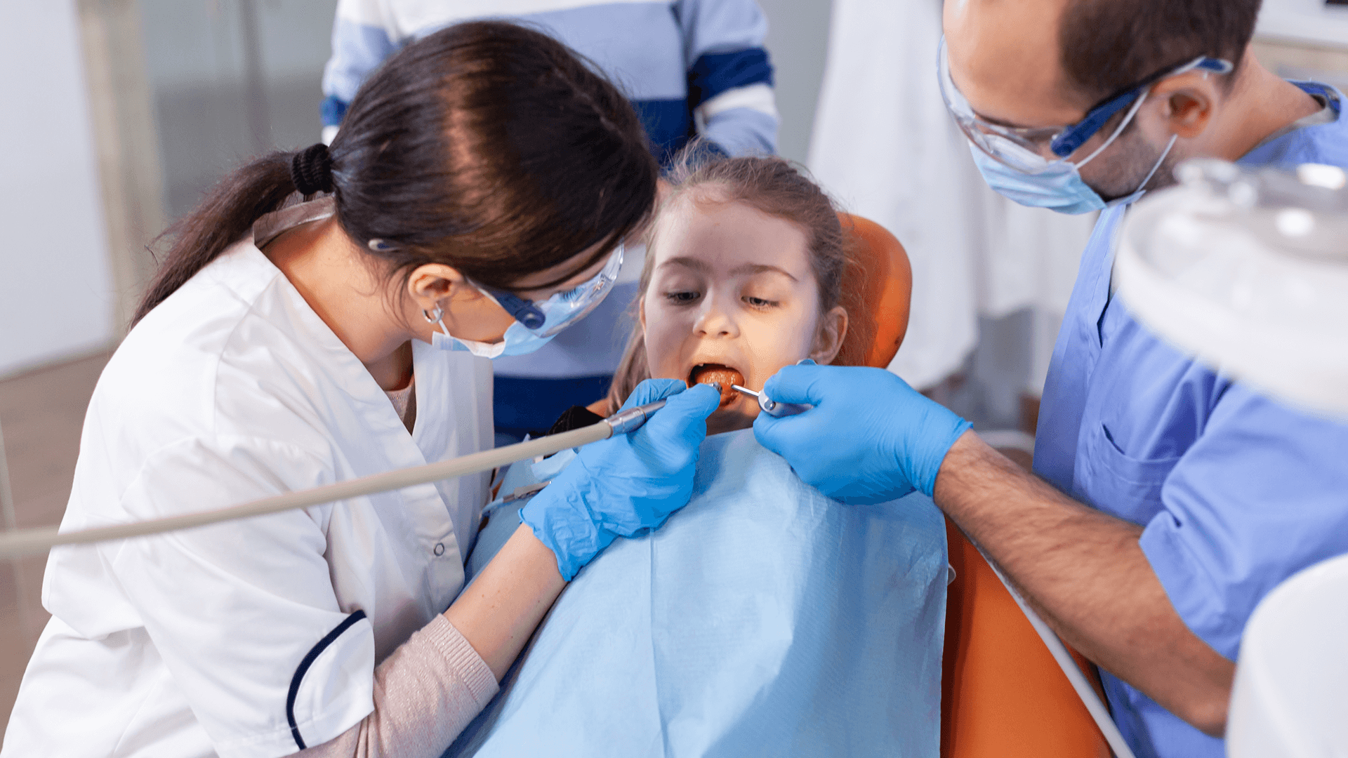 Girl being checked by dentists.