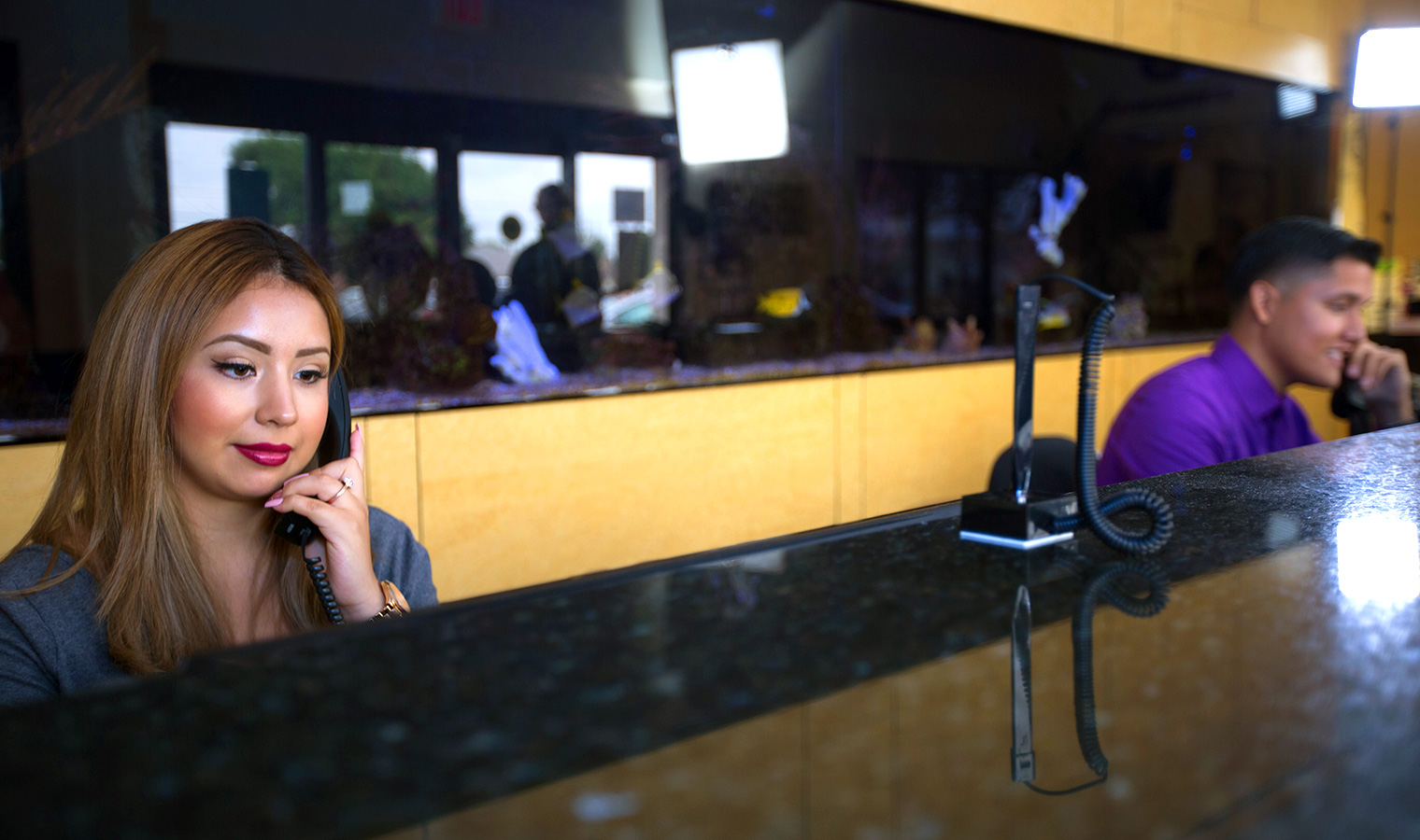 Two front desk staff talking on the phone at a dental office.